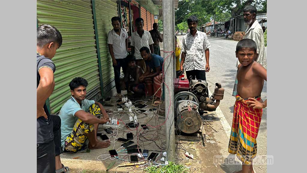 ময়না বাজারে মামুন শেখের জেনারেটর ভাড়া করে মোবাইলে চার্জ করছেন আশপাশের গ্রামের মানুষ।